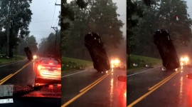 Ô tô bị treo ngược giữa đường trong mưa bão