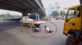 Video: Đi thẳng ở làn rẽ trái, xe máy suýt lọt vào gầm xe tải